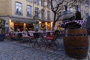 Cosy scene of tables outside a 'bouchon' restaurant at twilight in Lyon, France